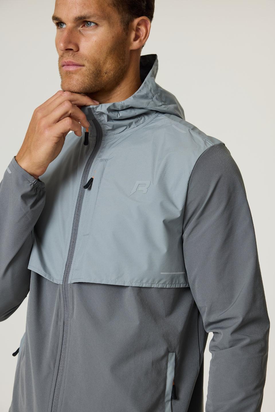 Man wearing slate and light grey Reprimo Summit Windbreaker jacket with hood and zip front