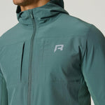 Man wearing botanical green Reprimo Glide Jacket with hood and front zipper