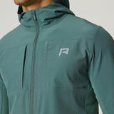 Man wearing botanical green Reprimo Glide Jacket with hood and front zipper