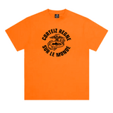 Corteiz Regne Sur Le Monde Tee in orange color displayed on a flat surface