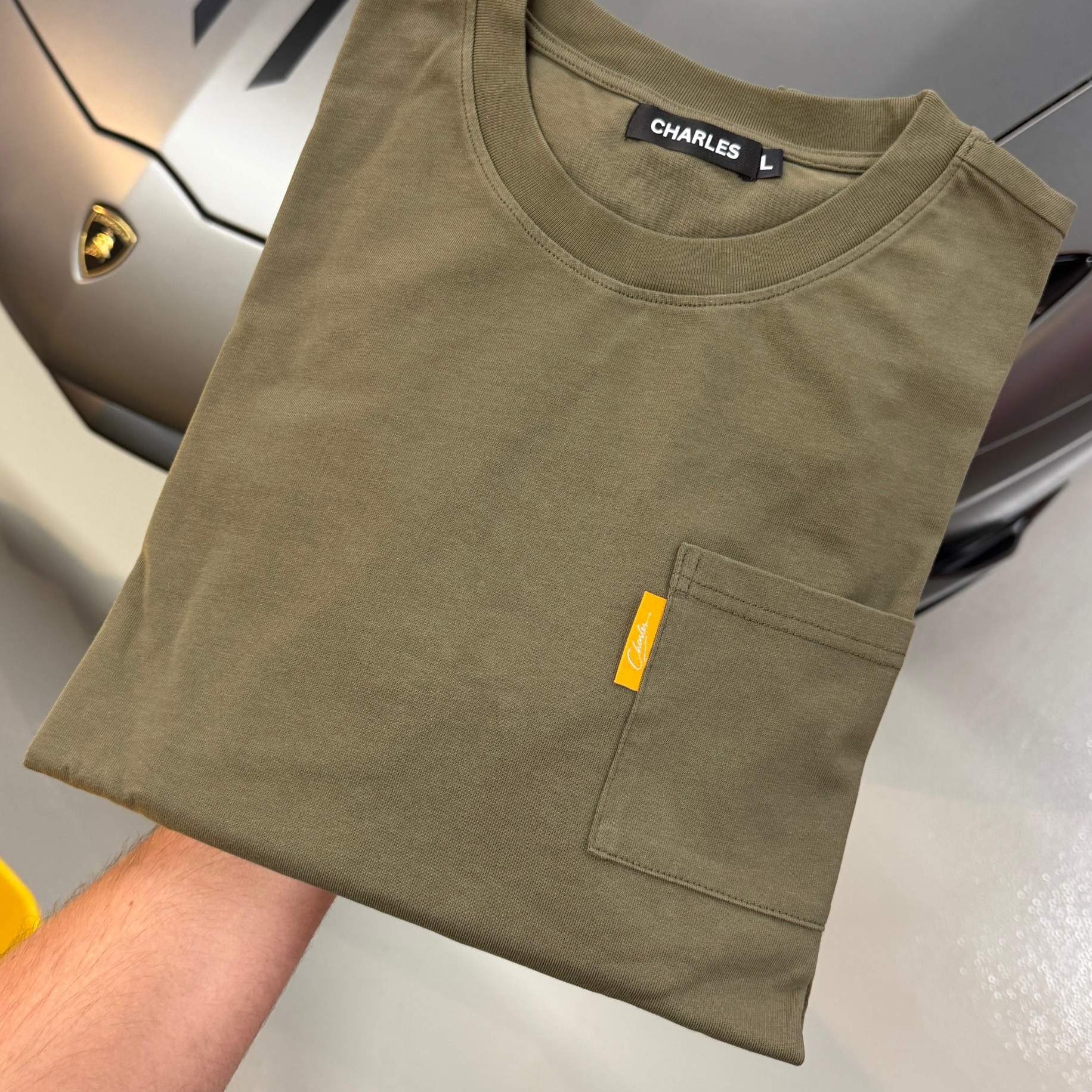 Studio By Charles khaki long sleeve tee with front pocket folded on car hood background