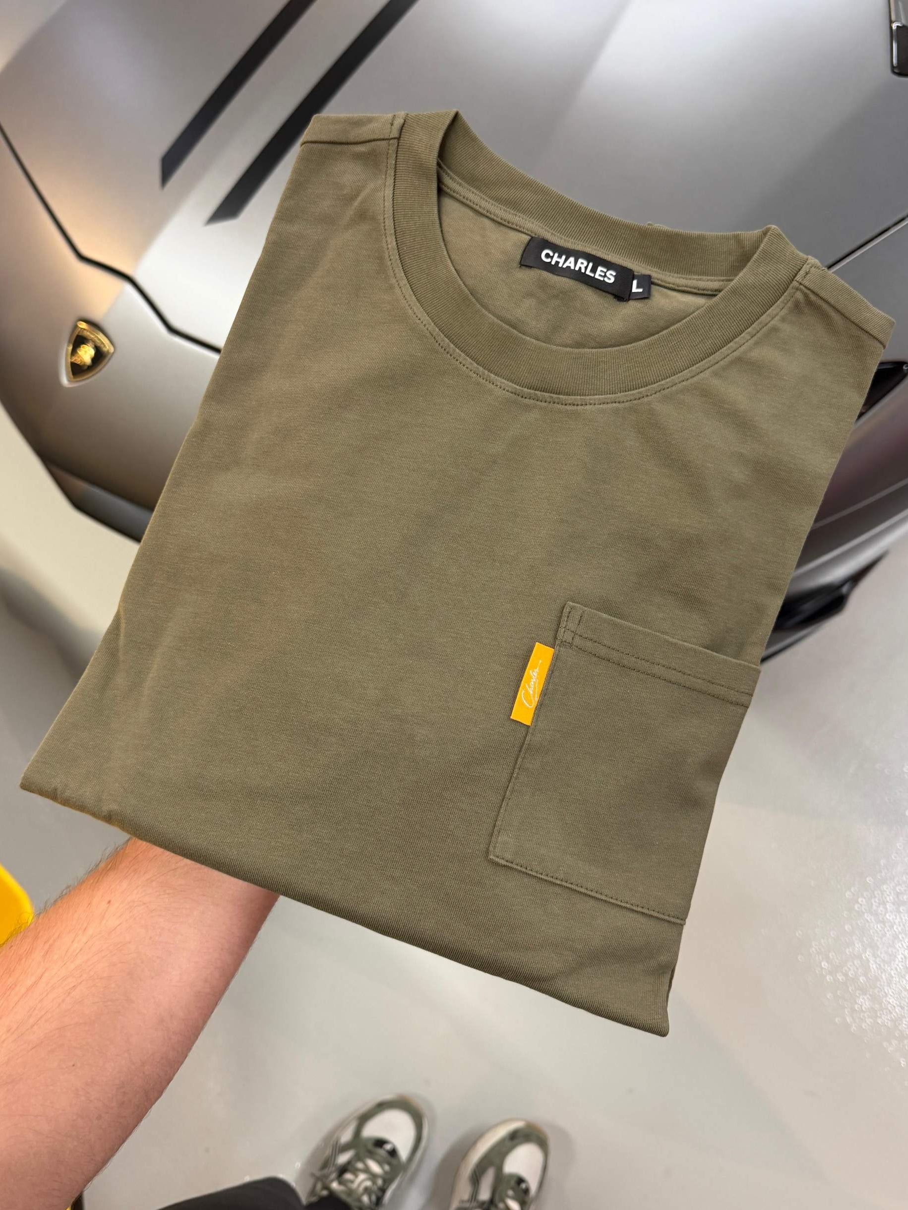 Studio By Charles khaki long sleeve tee with front pocket folded on car hood background