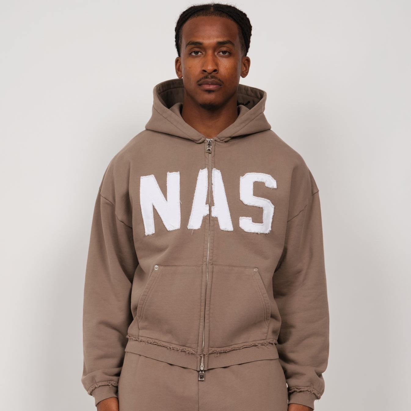 Taupe Natural Art Studio hoodie with appliqué logo, raw cuff seams, metal rivet pockets, luxury athletic fit, and dropped shoulders