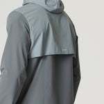 Man wearing Reprimo Summit Windbreaker in slate and light grey with hood and reflective details, shown from the back