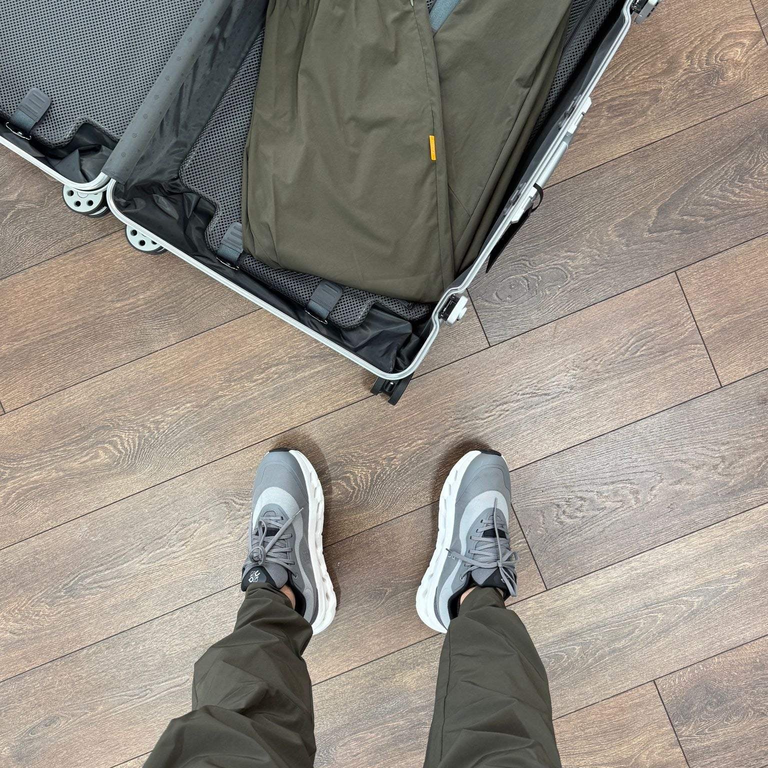 Studio By Charles khaki trackpants packed in suitcase and worn with sneakers on wooden floor