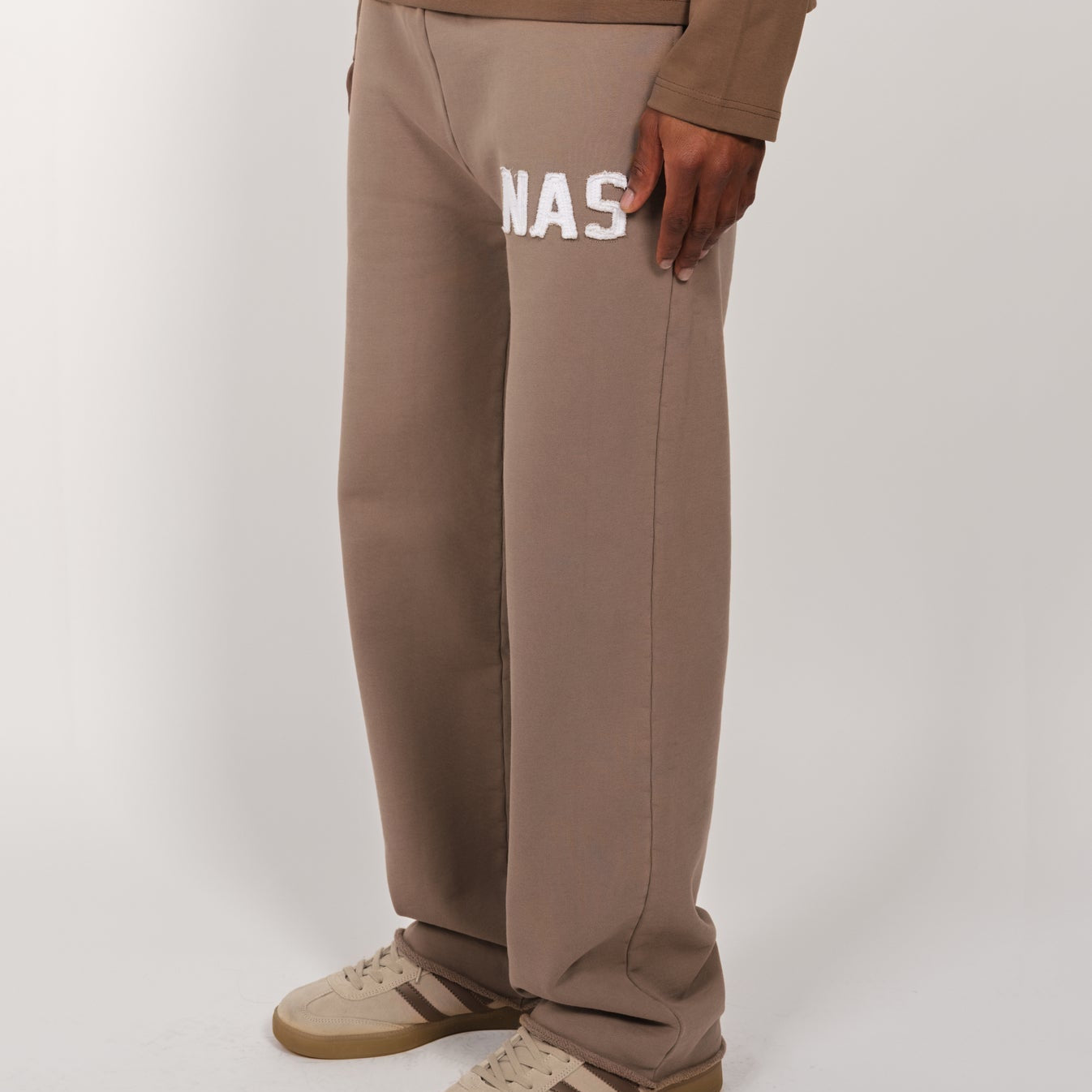 Taupe Natural Art Studio sweatpants with appliqué logo, raw edges, and elastic waistband