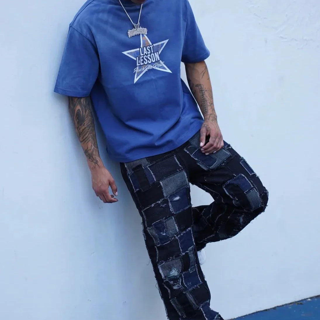 Last Lesson Blue Washed Star T-shirt worn by model with braided hair and patchwork jeans against white wall
