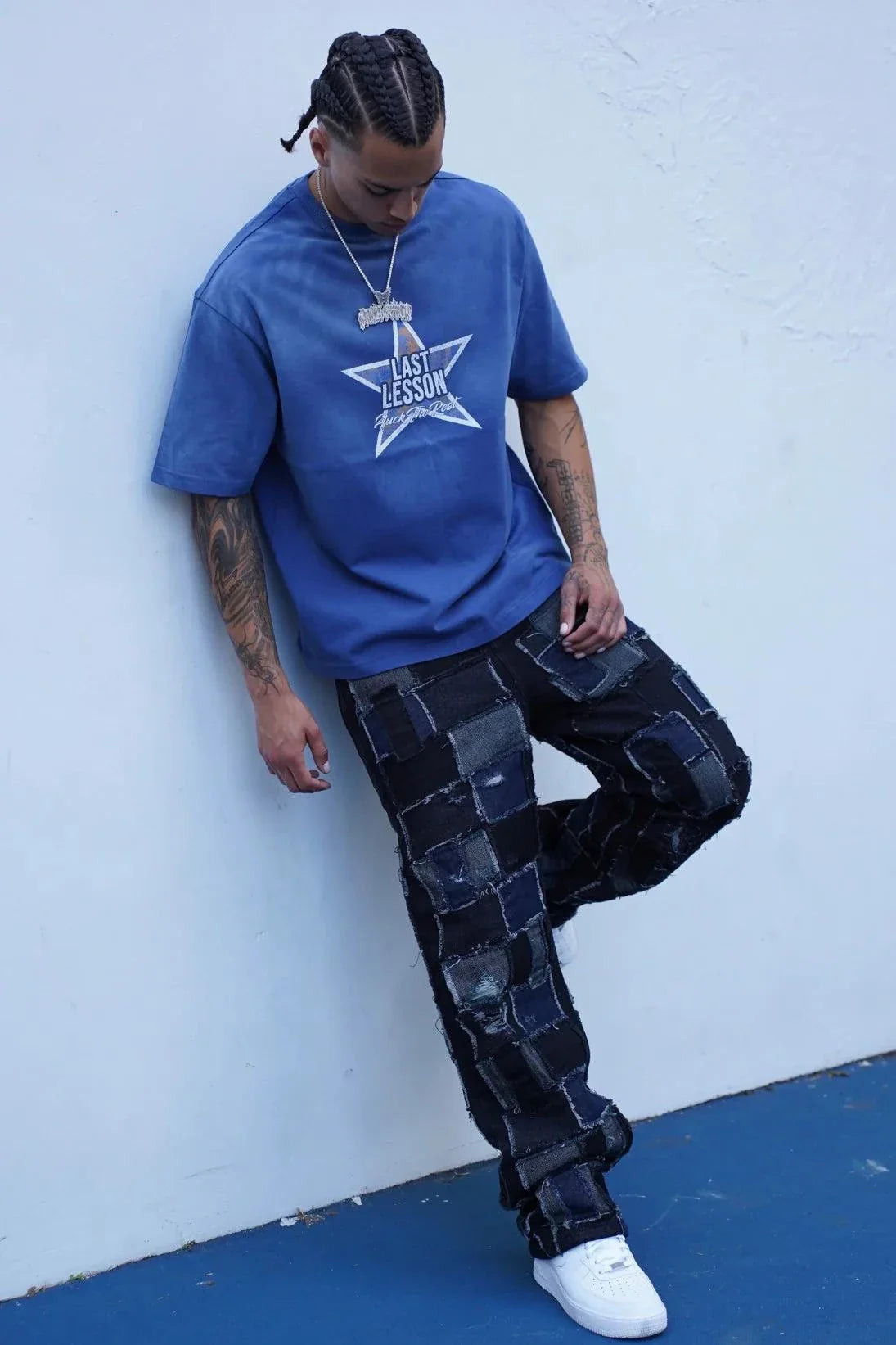 Last Lesson Blue Washed Star T-shirt worn by model with braided hair and patchwork jeans against white wall