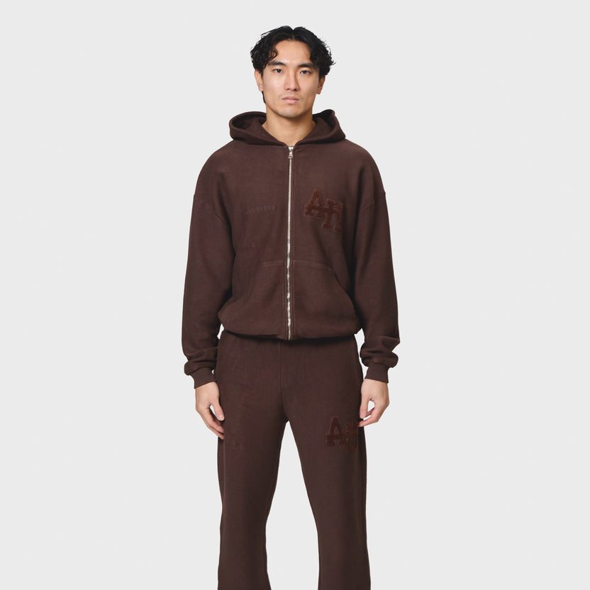 Annie Hood College Zip in washed brown, 500gsm brushback cotton, relaxed fit hoodie with garment dye, modeled by 6'0" male with 31 waist wearing size M