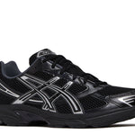 Black Gel 1130 athletic shoe with silver detailing and mesh upper