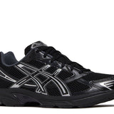 Black Gel 1130 athletic shoe with silver detailing and mesh upper