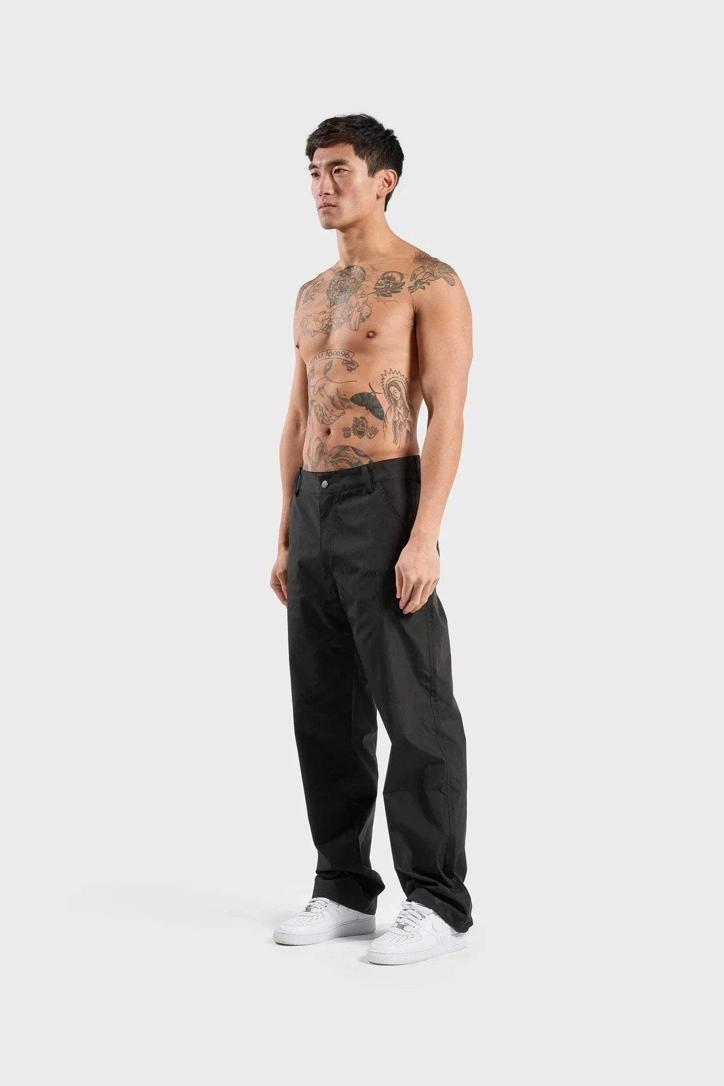 Black ANNIE HOOD nylon track pants, wind and water-resistant, shown cuffed with pull cords.
