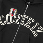 Black Corteiz Arch Shield zip hoodie with crest and bold lettering