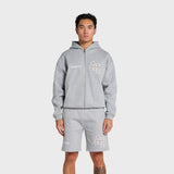 Man wearing grey ANNIE HOOD College Zip hoodie with dropped shoulder and double embroidery logo, paired with matching shorts