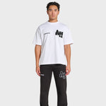Male model wearing white ANNIE HOOD college t-shirt with black logo and black pants with matching ANNIE HOOD branding