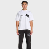 Male model wearing white ANNIE HOOD college t-shirt with black logo and black pants with matching ANNIE HOOD branding