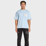 Man wearing baby blue ANNIE HOOD college t-shirt and black pants with logos