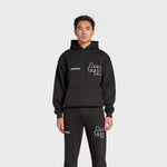 Black ANNIE HOOD College Hoody with dropped shoulder, boxy fit, and double embroidery logo worn by male model