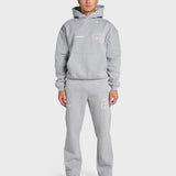 Model wearing grey ANNIE HOOD College Hoody with dropped shoulder and double embroidery logo, paired with matching joggers