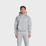 Man wearing grey ANNIE HOOD College Hoody with dropped shoulder and double embroidery logo.