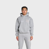 Man wearing grey ANNIE HOOD College Hoody with dropped shoulder and double embroidery logo.