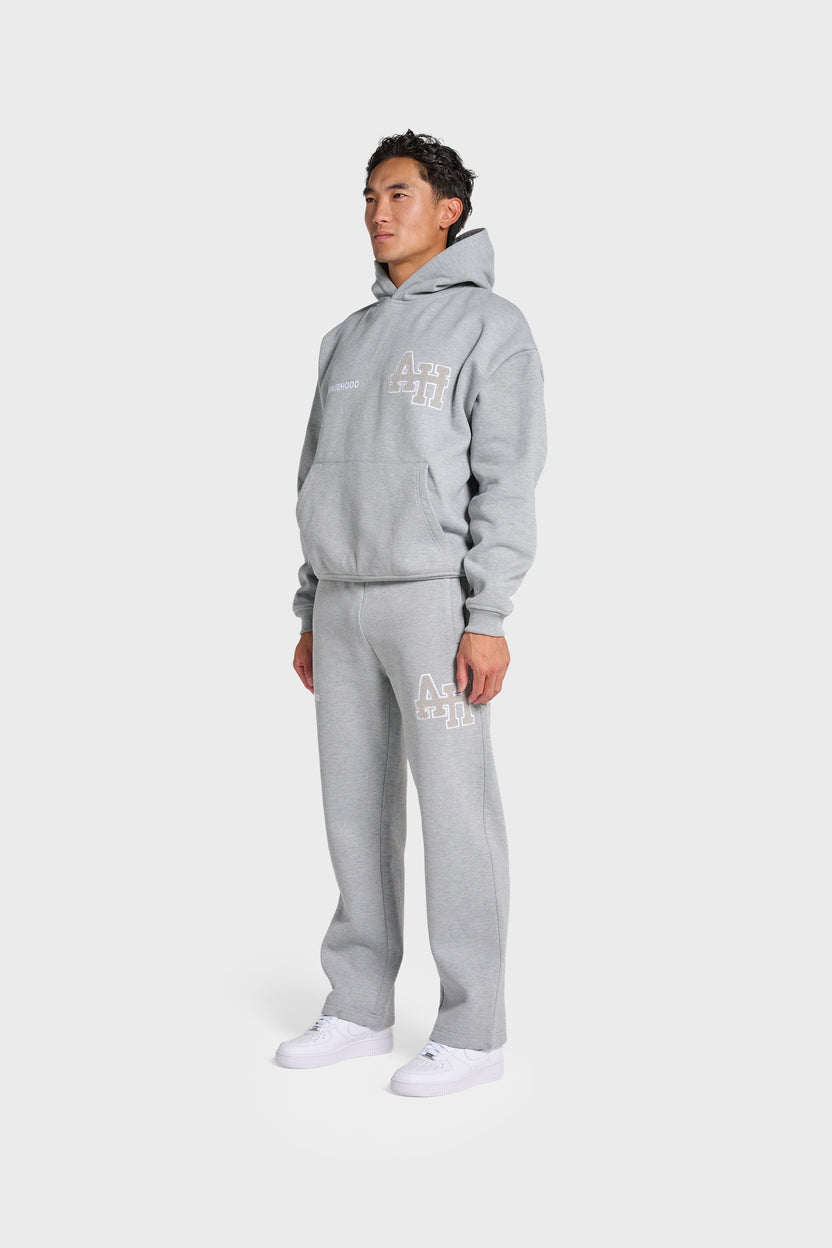 Man wearing ANNIE HOOD College Hoody grey oversized fit with matching sweatpants and white sneakers