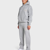 Man wearing ANNIE HOOD College Hoody grey oversized fit with matching sweatpants and white sneakers