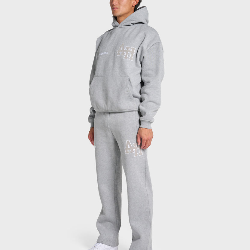 Man wearing ANNIE HOOD College Hoody grey oversized fit with matching sweatpants and white sneakers
