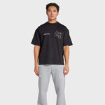 Man wearing black ANNIE HOOD College T-Shirt with gray sweatpants on white background