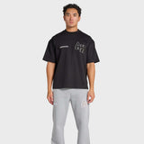 Man wearing black ANNIE HOOD College T-Shirt with gray sweatpants on white background