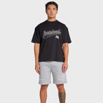 Man wearing black ANNIE HOOD Baseball T-shirt and gray shorts