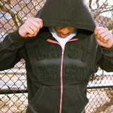 Last Lesson Appliqué Black Hoodie worn by a model outdoors.