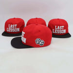 Last Lesson SnapBack Hat in red with black brim and embroidered dice design side logo