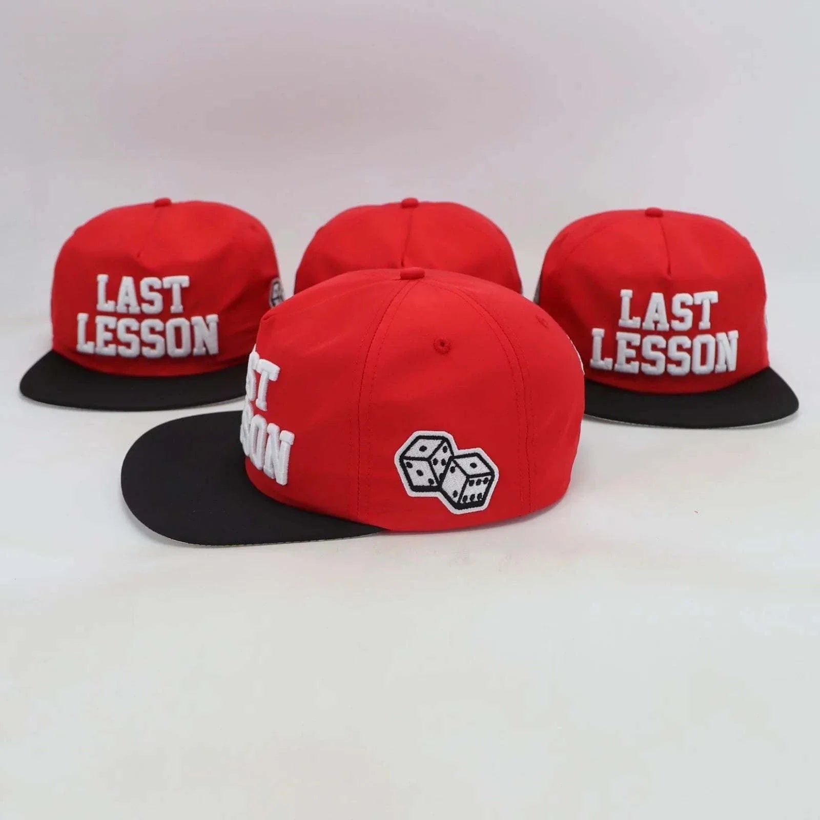 Last Lesson SnapBack Hat in red with black brim and embroidered dice design side logo