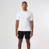 Man wearing white Cova Daily T-Shirt with black shorts standing against white background