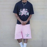 Last Lesson All-Star Black T-Shirt worn by model against brick wall.