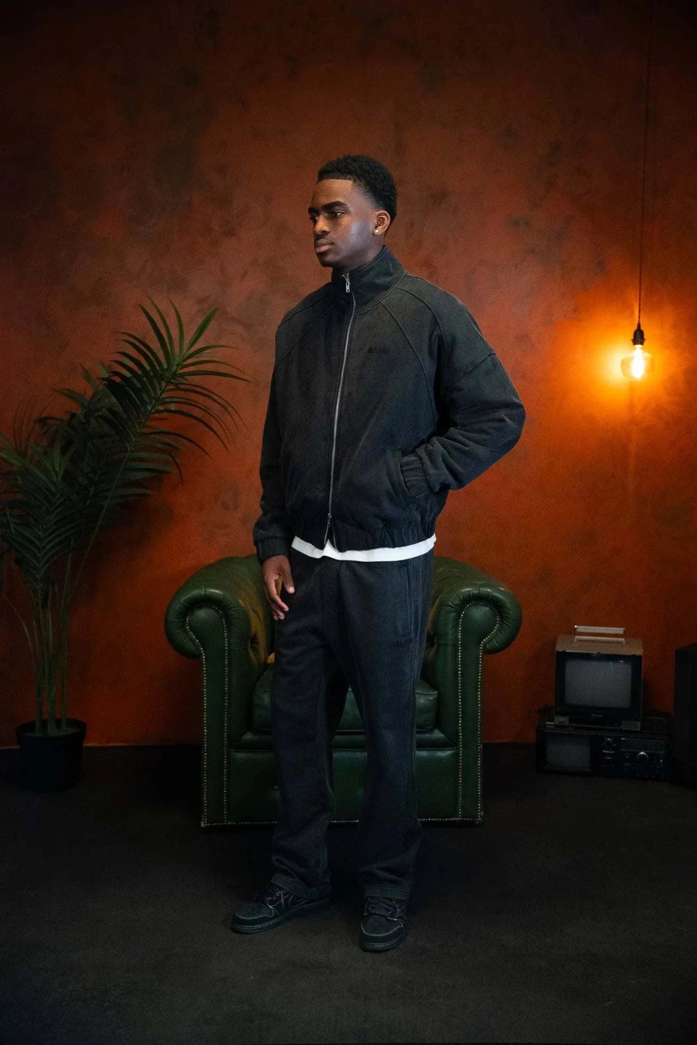 Man wearing Siarr Washed Quilted Bomber Jacket in Washed Black standing indoors with vintage decor background