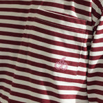 Close-up of Cherry Location OG Stripe T-Shirt with red and white stripes and cherry embroidery on pocket