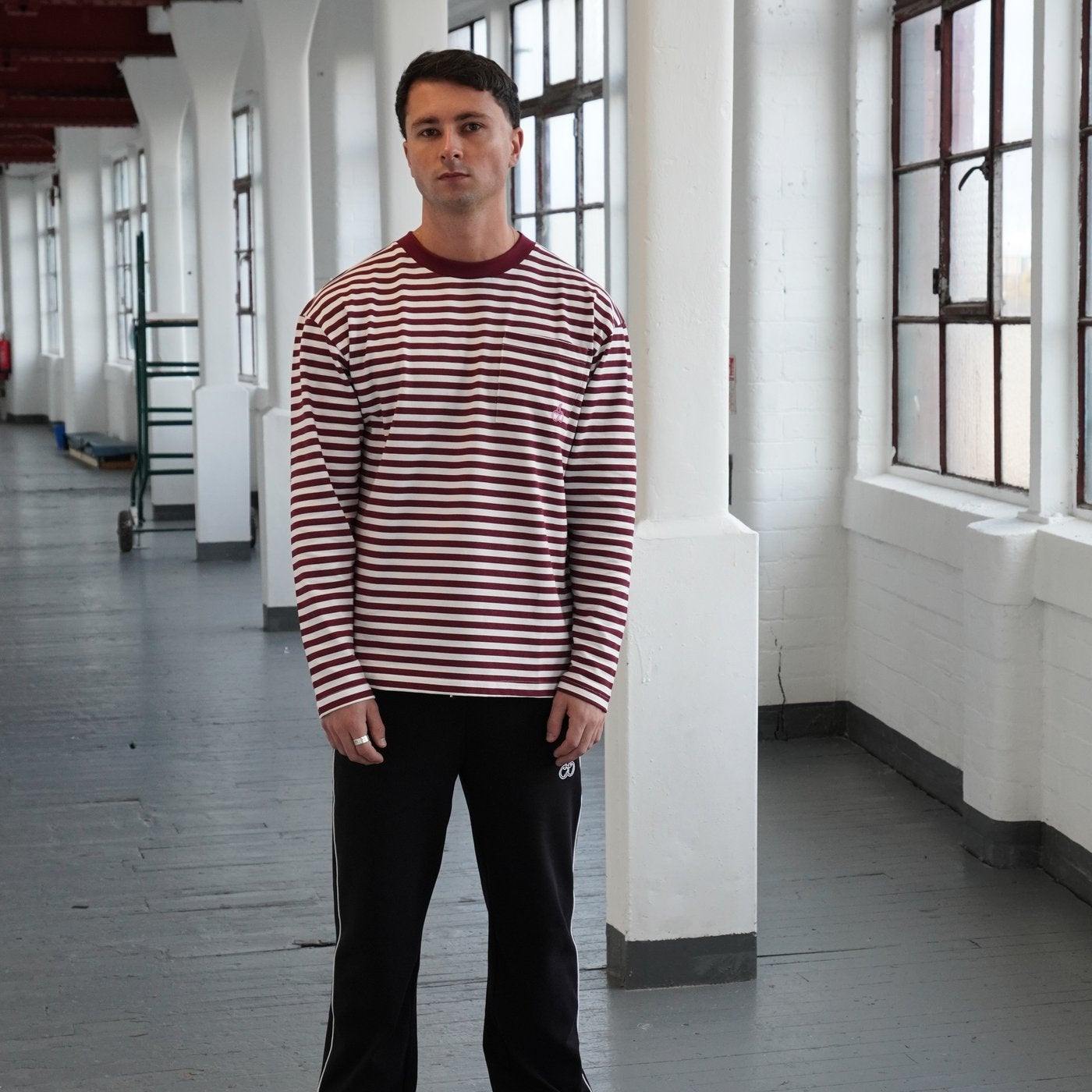 Man wearing Cherry Location OG Stripe T-Shirt with red and white stripes in an indoor setting