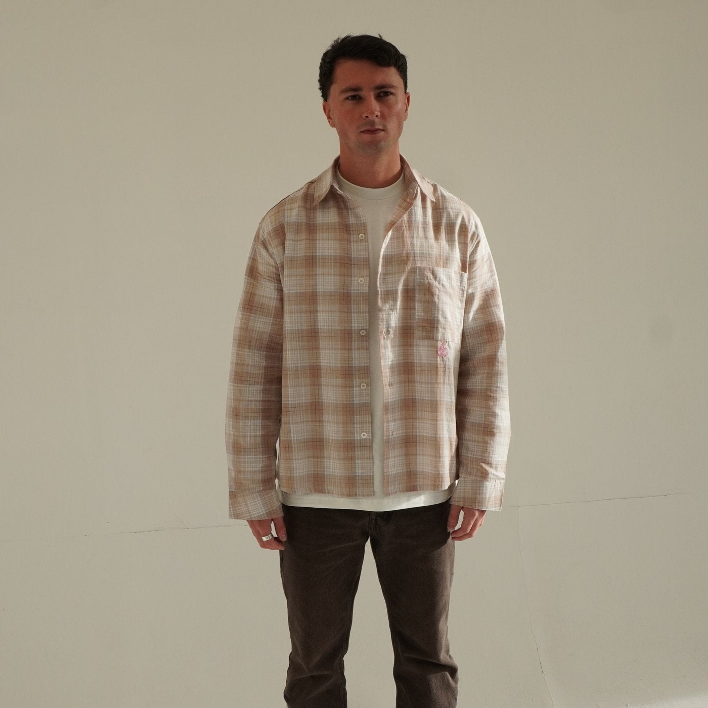 Man wearing Cherry Location Beige Shirt with plaid pattern and front pocket standing against plain background