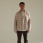 Man wearing Cherry Location Beige Shirt with plaid pattern and front pocket standing against plain background