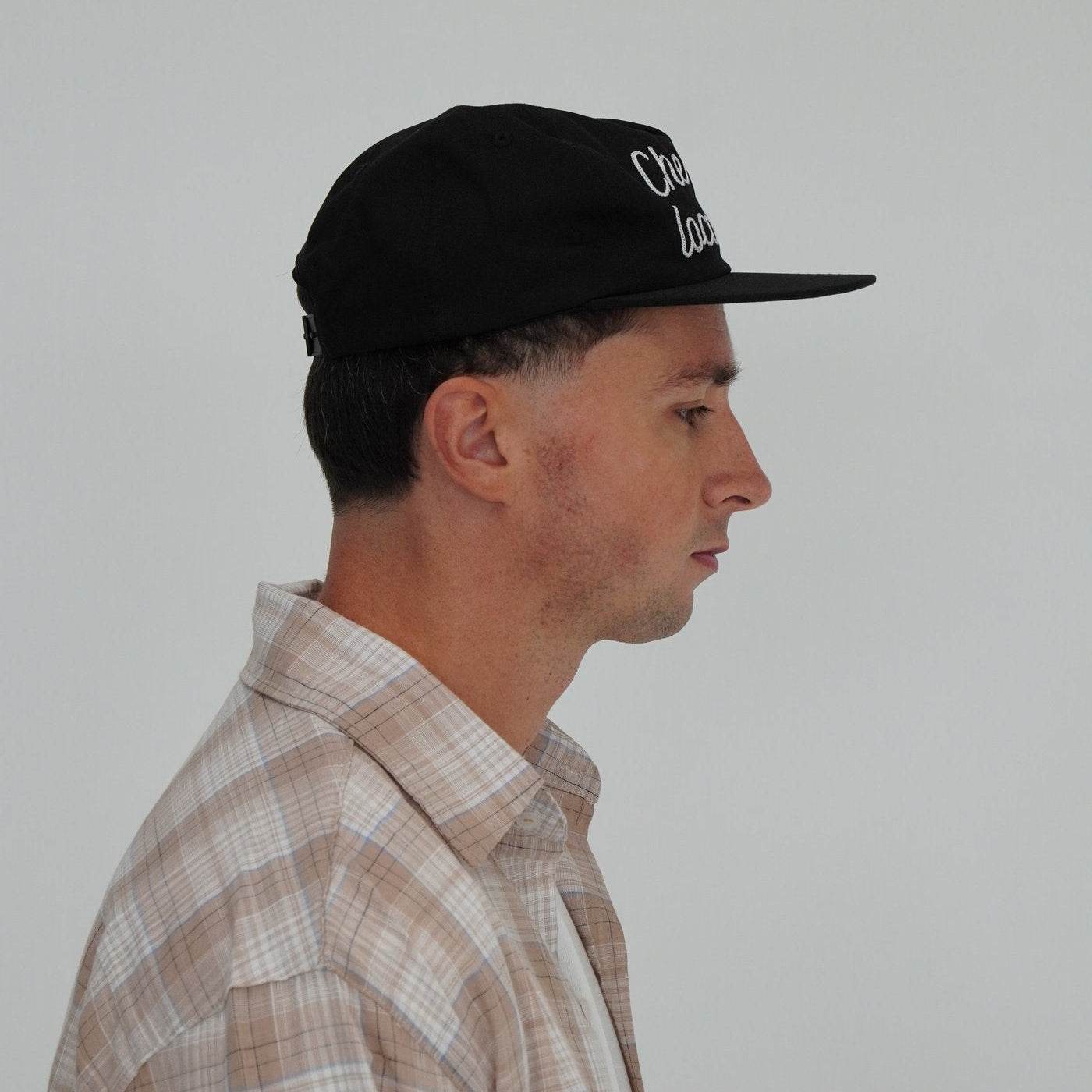 Side view of man wearing Cherry Location Black Cap with embroidered text