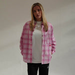 Woman wearing Cherry Location pink plaid shirt over white t-shirt