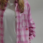 woman wearing Cherry Location Pink Shirt plaid button-up with embroidered cherry detail over white t-shirt