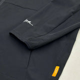 Close-up of Studio By Charles black track jacket sleeve and pocket with logo tags