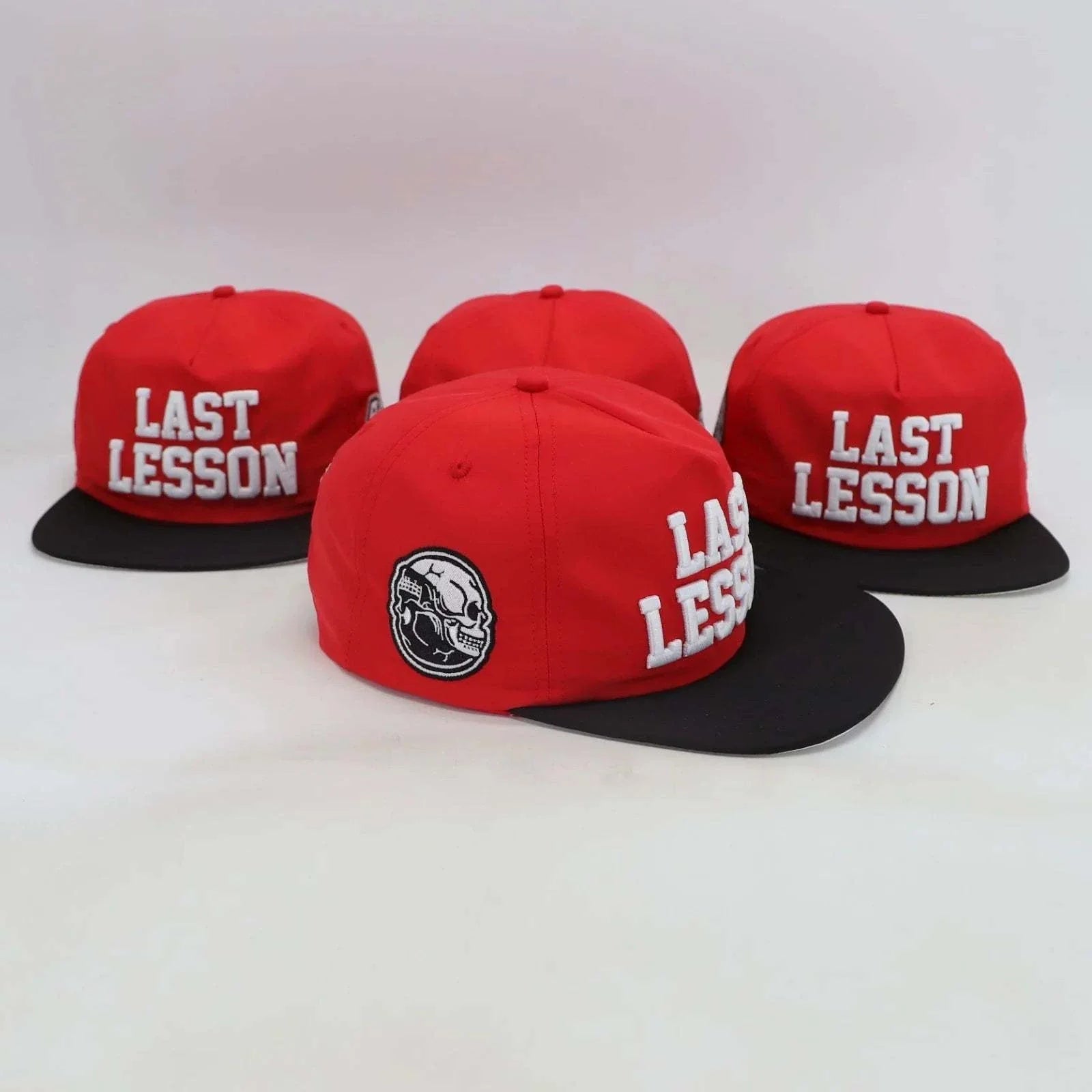 Red Last Lesson SnapBack Hat with black brim and skull logo on side