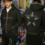 Last Lesson Appliqué Black Hoodie with star design and textured front in urban setting.