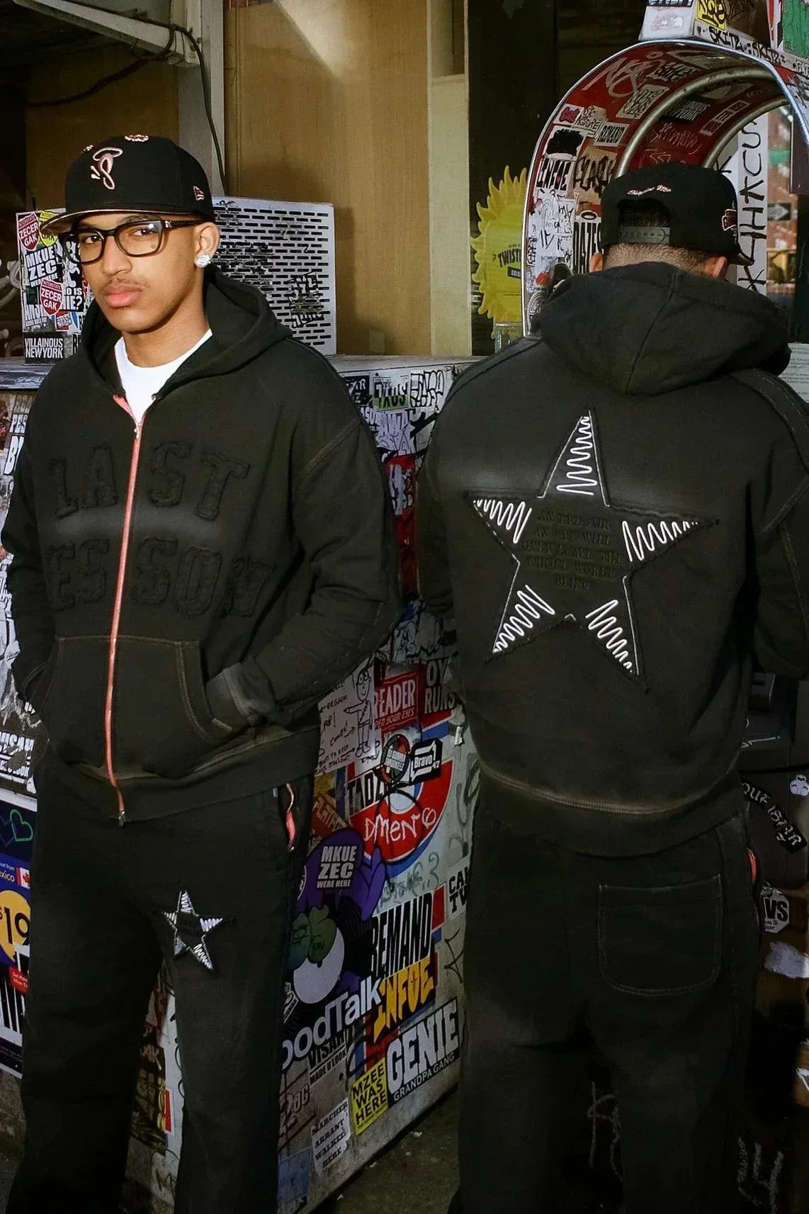 Last Lesson Appliqué Black Hoodie with star design and textured front in urban setting.