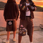 Men wearing Last Lesson Badged Casazøna Shorts with patches at sunset outdoor setting