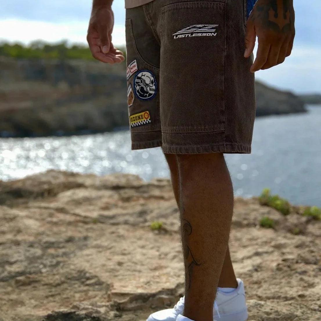 Last Lesson badged Casazøna shorts with patches worn by a person outdoors near water
